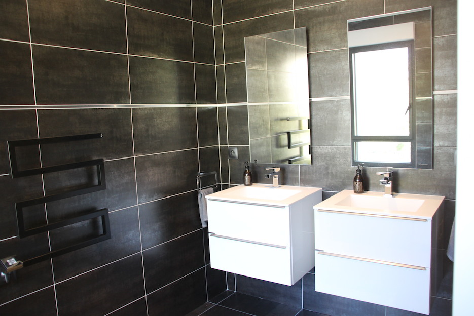 Salle de bains avec meubles suspendus et sèche serviette noir