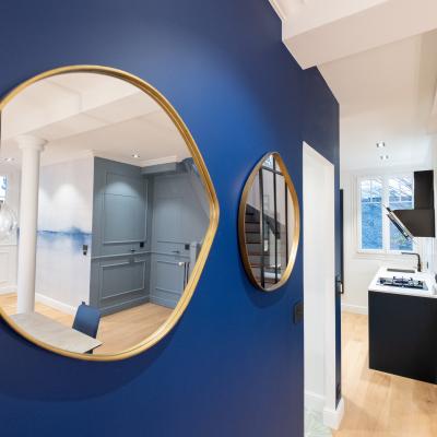 Miroir or sur mur bleu